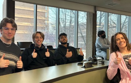 Smiling FIG members giving thumbs up in a classroom