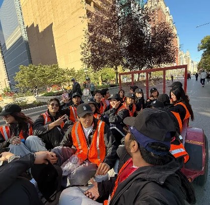 FIG volunteers in orange safety vests sitting together on a Chicago street during the marathon